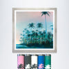 Palms fine art print by Nick Purser displayed in a silver-coloured frame above five colourful palm-decorated postal tubes.