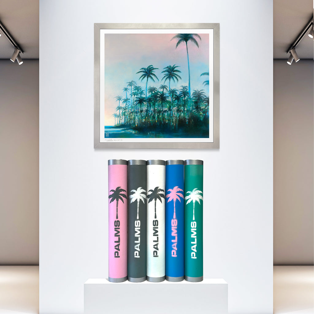 Framed Palms print by Nick Purser displayed on a gallery wall above five decorated postal tubes.